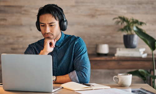 man wearing headphones working on laptop