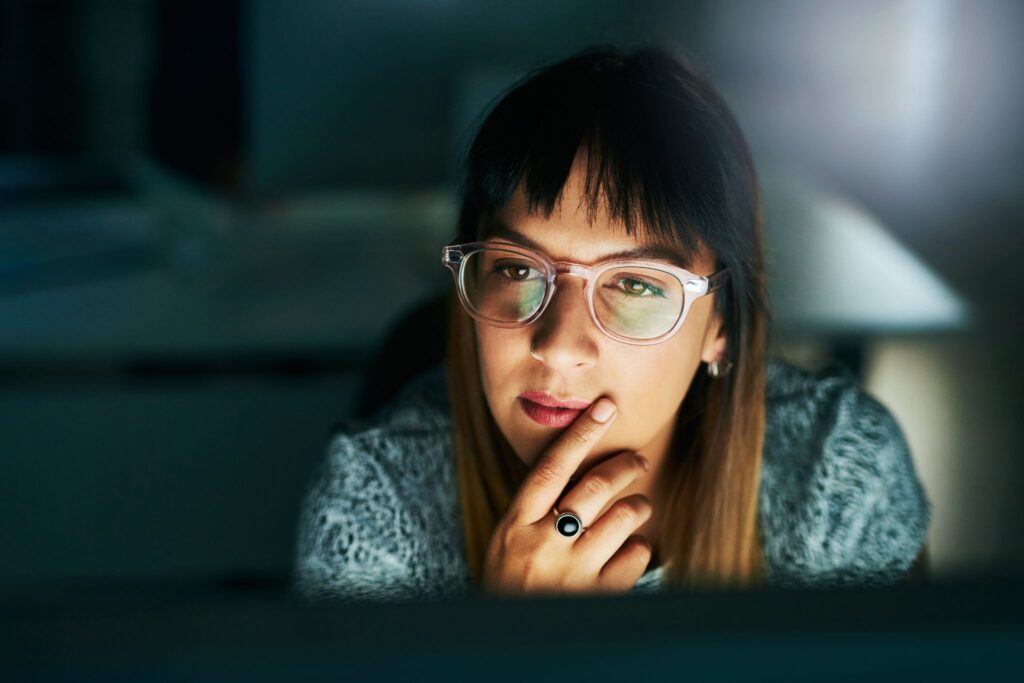 Woman using computer in the dark