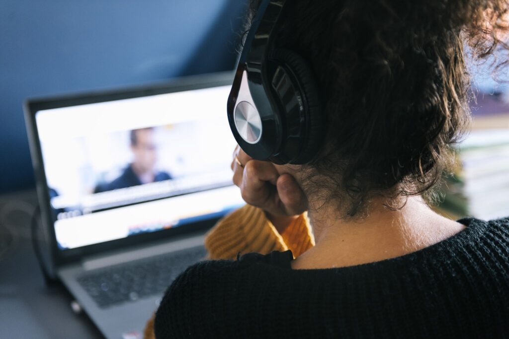 Employee with headphones watching a video on her laptop.